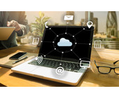 Laptop auf Tisch mit Cloud-Computing-Symbolen