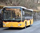 Ein Postauto fährt auf einer Landstrasse