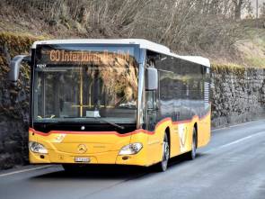 Ein Postauto fährt auf einer Landstrasse 