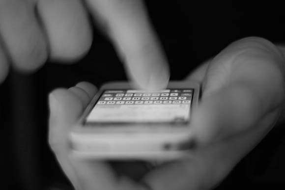Finger tippt Textnachricht auf Handy 
