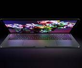 Das Foto zeigt ein halb geöffnetes MacBook Pro vor einem schwarzen Hintergrund