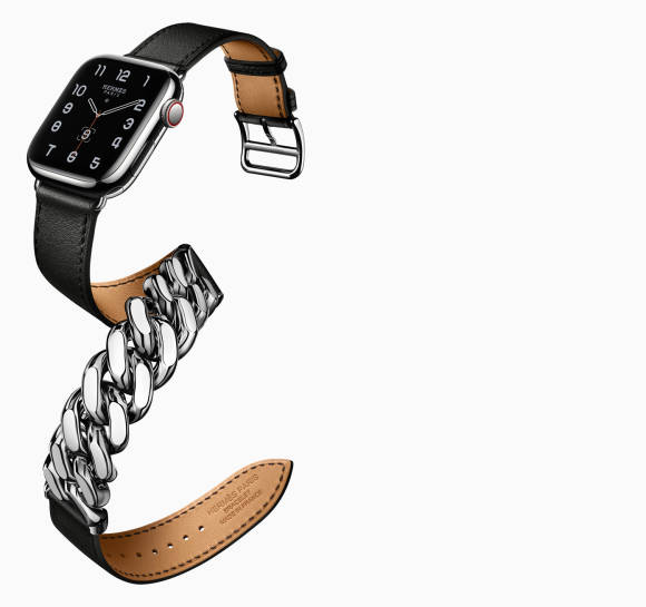Das Foto zeigt eine Apple Watch Hermès; das Lederband ist durch metallische Kettenglieder unterbrochen und lang genug, dass es doppelt um das Handgelenk geführt werden muss