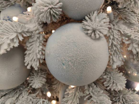 Nahaufnahme einer mit Kunstschnee bedeckten Weihnachtsbaumkugel