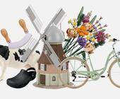 Stillleben aus Windmühle, Kuh, Fahrrad, Gummi-Clogs und Schnittblumen