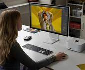 Eine Frau an einem Schreibtisch, auf dem ein Mac Studio steht