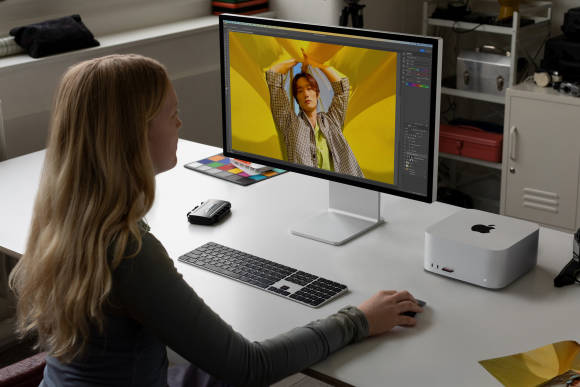 Eine Frau an einem Schreibtisch, auf dem ein Mac Studio steht 
