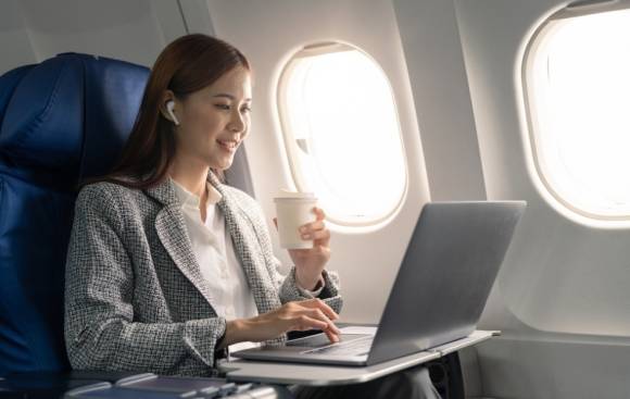 Frau mit Laptop im Flugzeug 